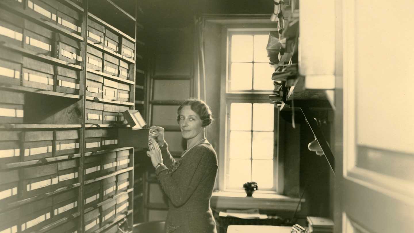 En kontordame i kigger i kortkartoteket på det gamle rådhus i Gentofte Kommune. Datering ca. 1935. Fotograf: Gustav Krog.